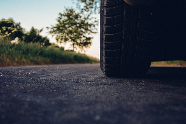 The back of a car tire on an ashpalt road surface as seen from the level of the road